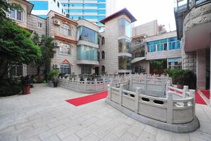 A courtyard with a red carpet, a stone bridge, and a fountain. - Kunming Southwest Hotel Yingbin Building (Kunhua Hospital) (Kunming)