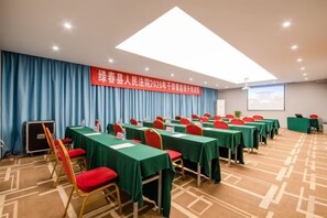 A conference room with multiple tables, chairs, and a projection screen. - Kunming Southwest Hotel Yingbin Building (Kunhua Hospital) (Kunming)