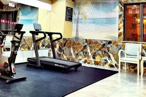 A gym with exercise equipment, a seating area, and a decorative wall. - Kunming Southwest Hotel Yingbin Building (Kunhua Hospital) (Kunming)