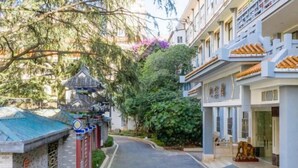 A narrow street with traditional architecture, including a pagoda and modern buildings. - Kunming Southwest Hotel Yingbin Building (Kunhua Hospital) (Kunming)