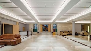 A spacious lobby with a marble floor, a central staircase, and leather seating areas. - Kunming Southwest Hotel Yingbin Building (Kunhua Hospital) (Kunming)