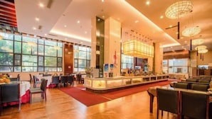 A spacious restaurant with a central counter, tables, and chairs arranged for dining. - Kunming Southwest Hotel Yingbin Building (Kunhua Hospital) (Kunming)