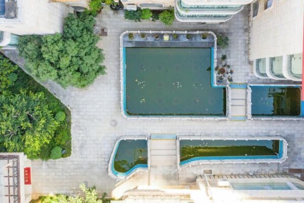 An aerial view of a courtyard with a central rectangular pool, surrounded by greenery and adjacent buildings. - Kunming Southwest Hotel Yingbin Building (Kunhua Hospital) (Kunming)