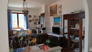 Un salon chaleureux avec un canapé, un téléviseur et un vase décoratif.