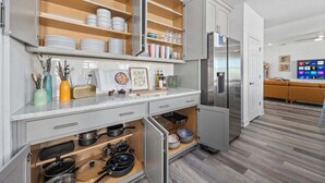 Een moderne keuken met ingebouwde kasten, een koelkast en een zithoek met een bank.