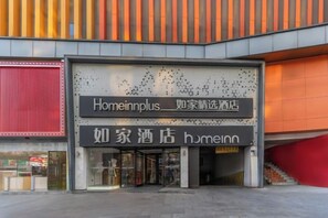 Een hotelingang met borden voor 'Homeinnplus' en 'Homeinn' hotel.