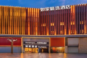 A hotel with a modern facade, illuminated signage, and a clear entrance. - Homeinn Plus Hotel (Qingdao Licun Subway Station Pedestrian Street) (Qingdao)