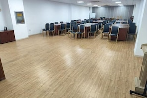 A conference room with rows of chairs, a whiteboard, and a wooden desk. - Homeinn Plus Hotel (Qingdao Licun Subway Station Pedestrian Street) (Qingdao)