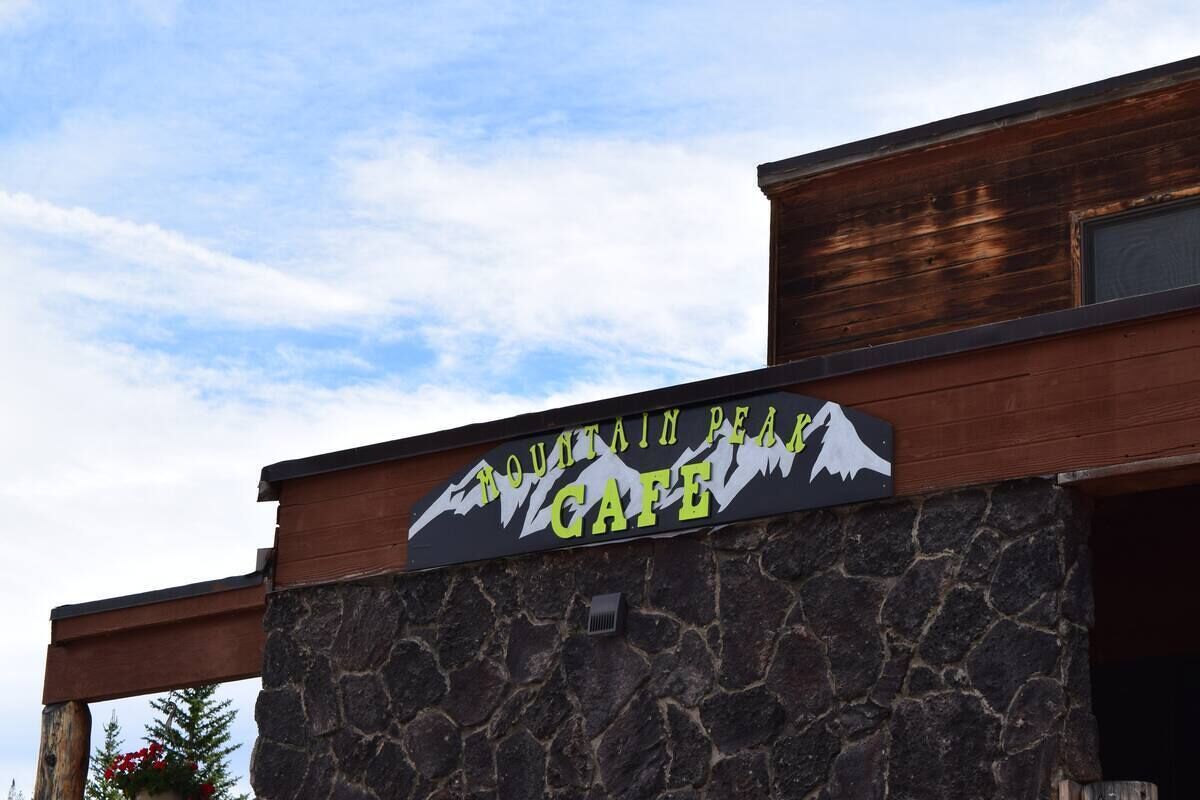 A sign for Mountain Peak Cafe with a mountain graphic.