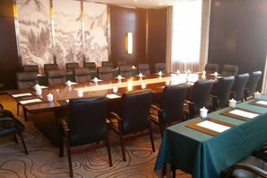 A conference room with a long table, chairs, and a large painting on the wall. - Xiaolangdi Zhongzhou International Hotel (Jiyuan)