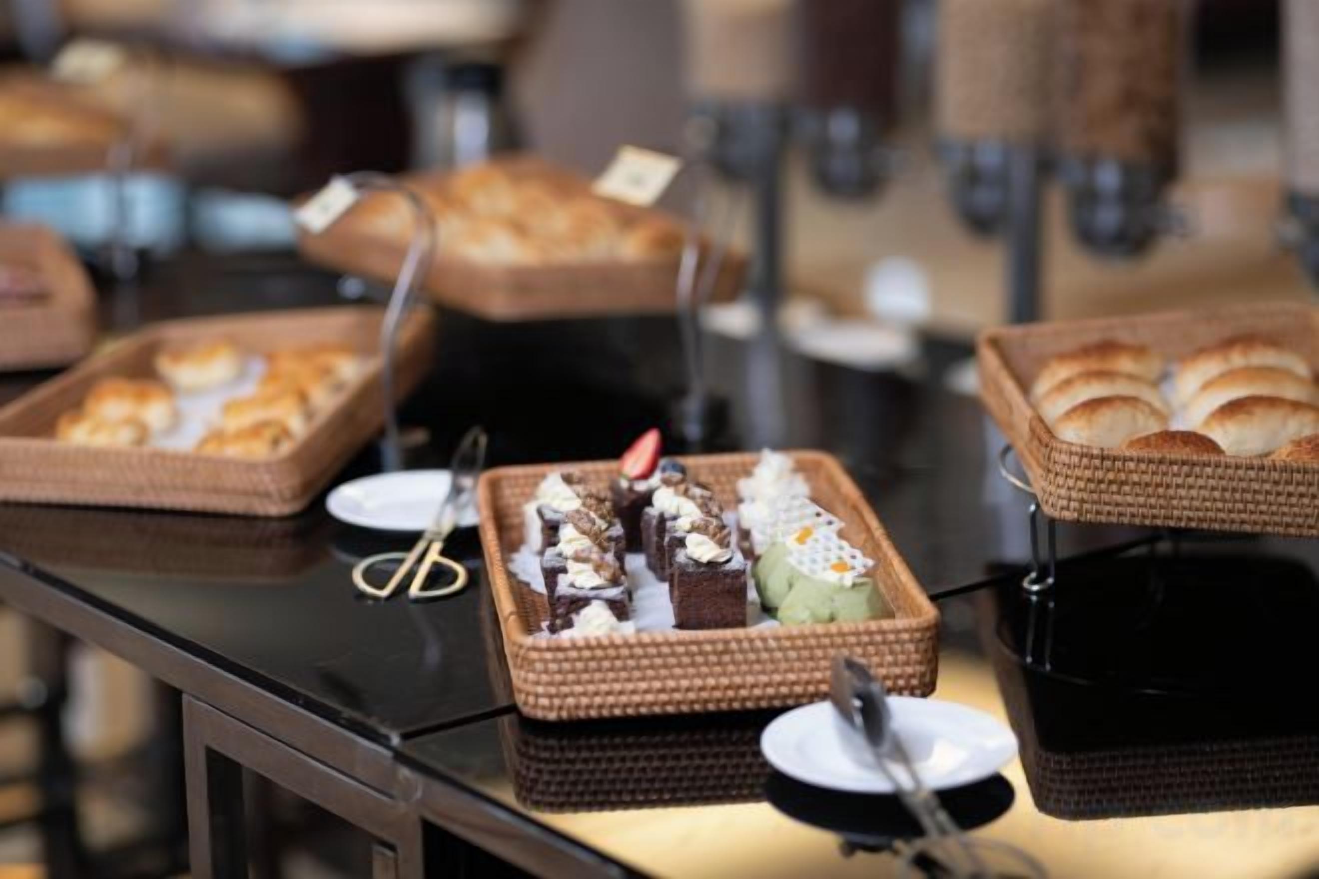 A buffet table with various food items in wicker baskets.