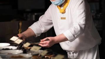 Un chef con uniforme blanco preparando comida en una cocina.