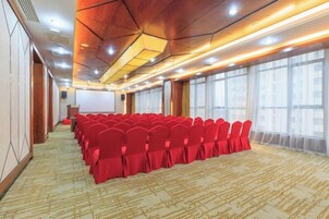 A conference room with rows of chairs, a podium, and large windows.