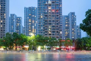 Un ensemble d’immeubles de grande hauteur, doté de plusieurs étages, d’une promenade piétonne et d’arbres au premier plan.
