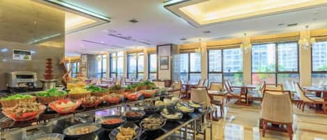 Zona de buffet con diferentes opciones de comida y un área de estar con mesas y sillas.