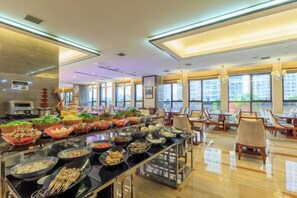 A buffet area with various food items and a seating area with tables and chairs. - Minfa Shiji Hotel Xiangyang, Zhuge Liang Square Wanda Plaza (Xiangyang)