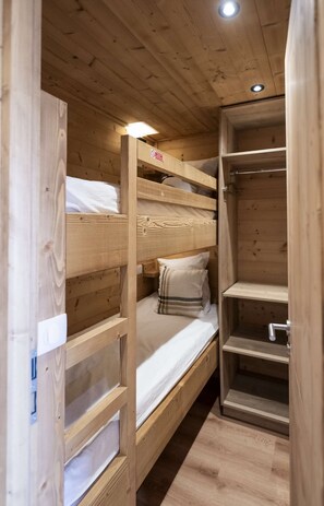 A bunk bed with a headboard, a bedside table, and a shelf unit. - Superb apartment for 4 people, 30m², 2 sleeping areas, renovated, at the foot of the slopes (VAL THORENS)