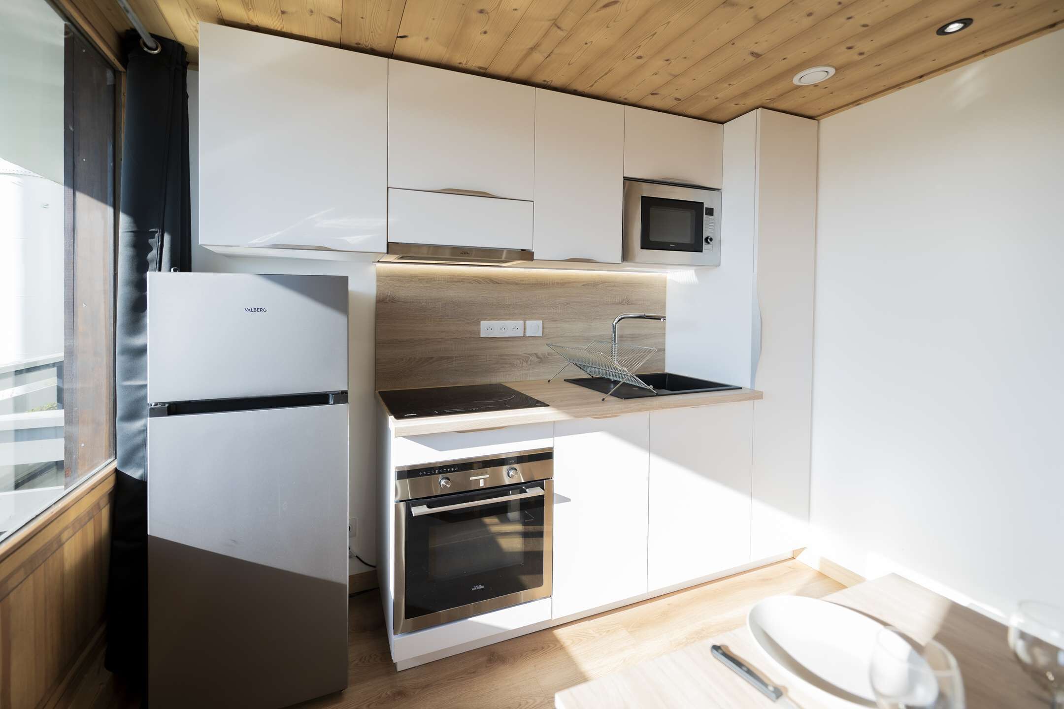 A compact kitchen with a built-in microwave, oven, and a small countertop.