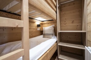 A bunk bed room with a wooden ceiling, a bedside table, and a wall-mounted light. - Superb apartment for 4 people, 30m², 2 sleeping areas, renovated, at the foot of the slopes (VAL THORENS)