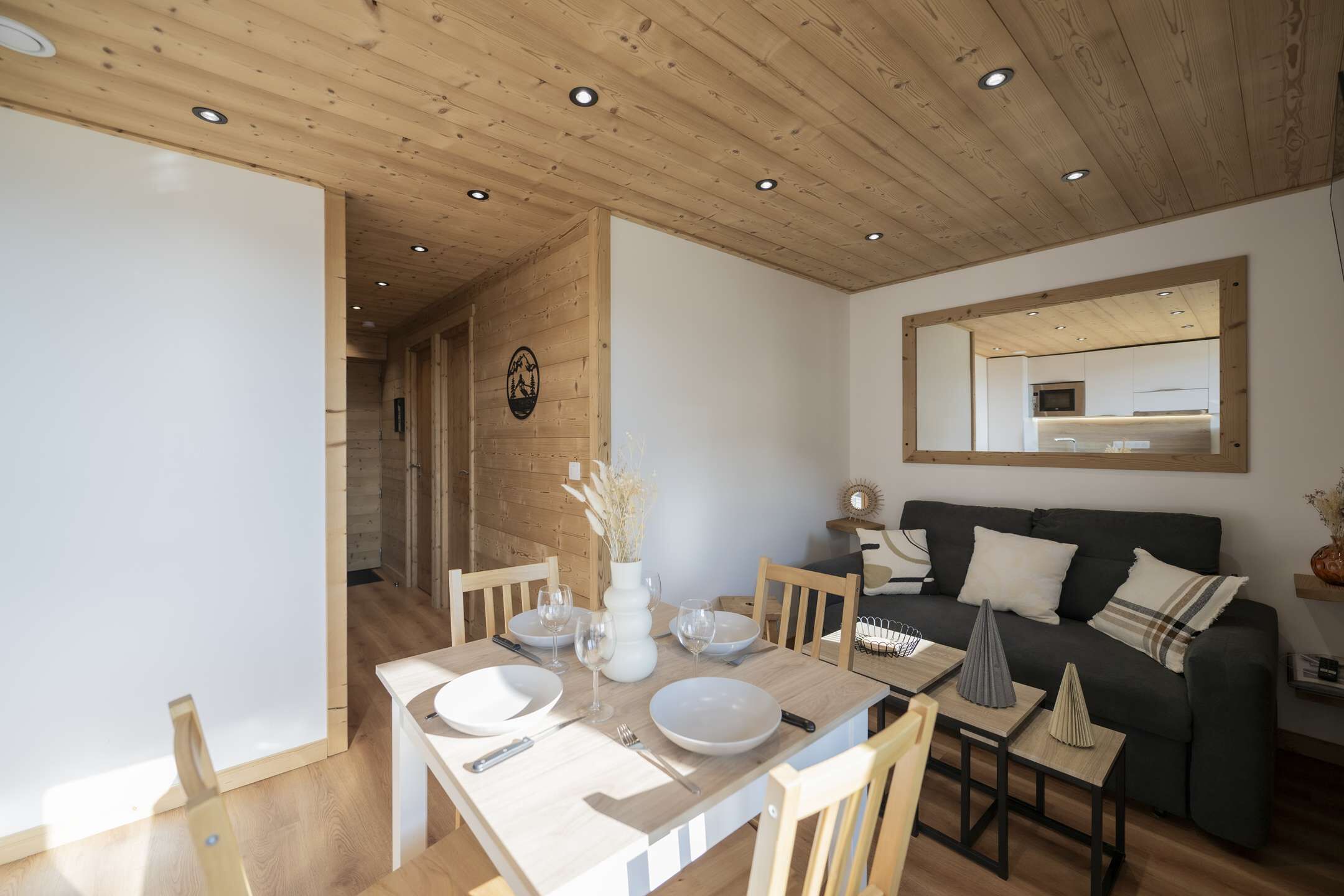 A modern interior with a dining area, a sofa, and a mirror.