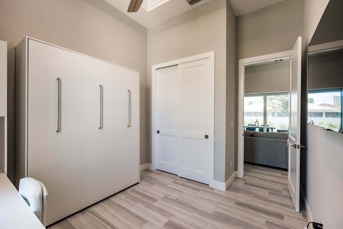 Une chambre moderne dotée d’une grande armoire, d’une porte fermée et donnant sur un balcon extérieur.