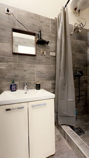 Basic Apartment | Bathroom | Shower, free toiletries, hair dryer, towels