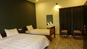 A hotel room with two beds, a chair, a desk, a mirror, and a curtain.