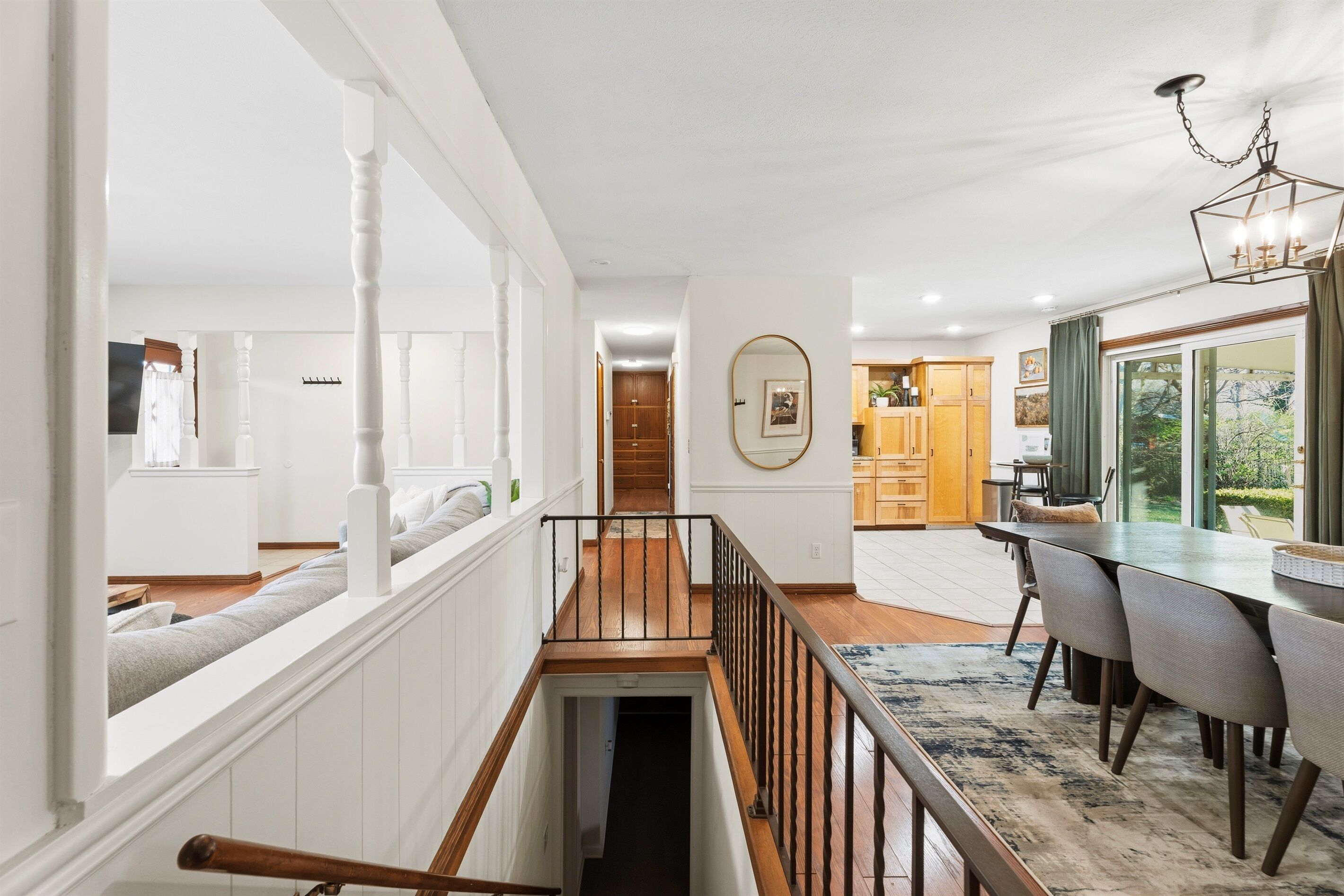 Un intérieur moderne comprenant un escalier, un coin repas et une cuisine.