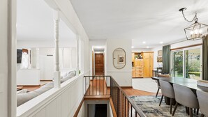 A modern interior with a staircase, dining area, and kitchen. - ICT Bunkhouse 2 King Beds, Family Friendly Retreat (Wichita)