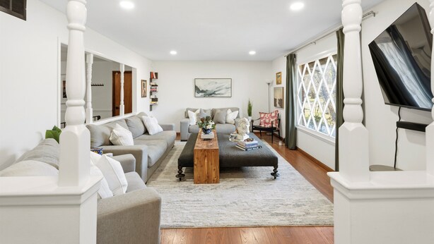 A modern living room with a sofa set, a coffee table, and a TV mounted on the wall. - ICT Bunkhouse 2 King Beds, Family Friendly Retreat (Wichita)