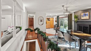 A spacious kitchen with a dining area, a fireplace, and a view of the outdoors. - ICT Bunkhouse 2 King Beds, Family Friendly Retreat (Wichita)