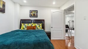Un dormitorio con una cama, una puerta y un pasillo que da a otra habitación.