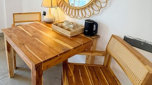 A wooden dining table with chairs, a lamp, a tray with cups, and a coffee maker. - OLA Tangalle (Tangalle)