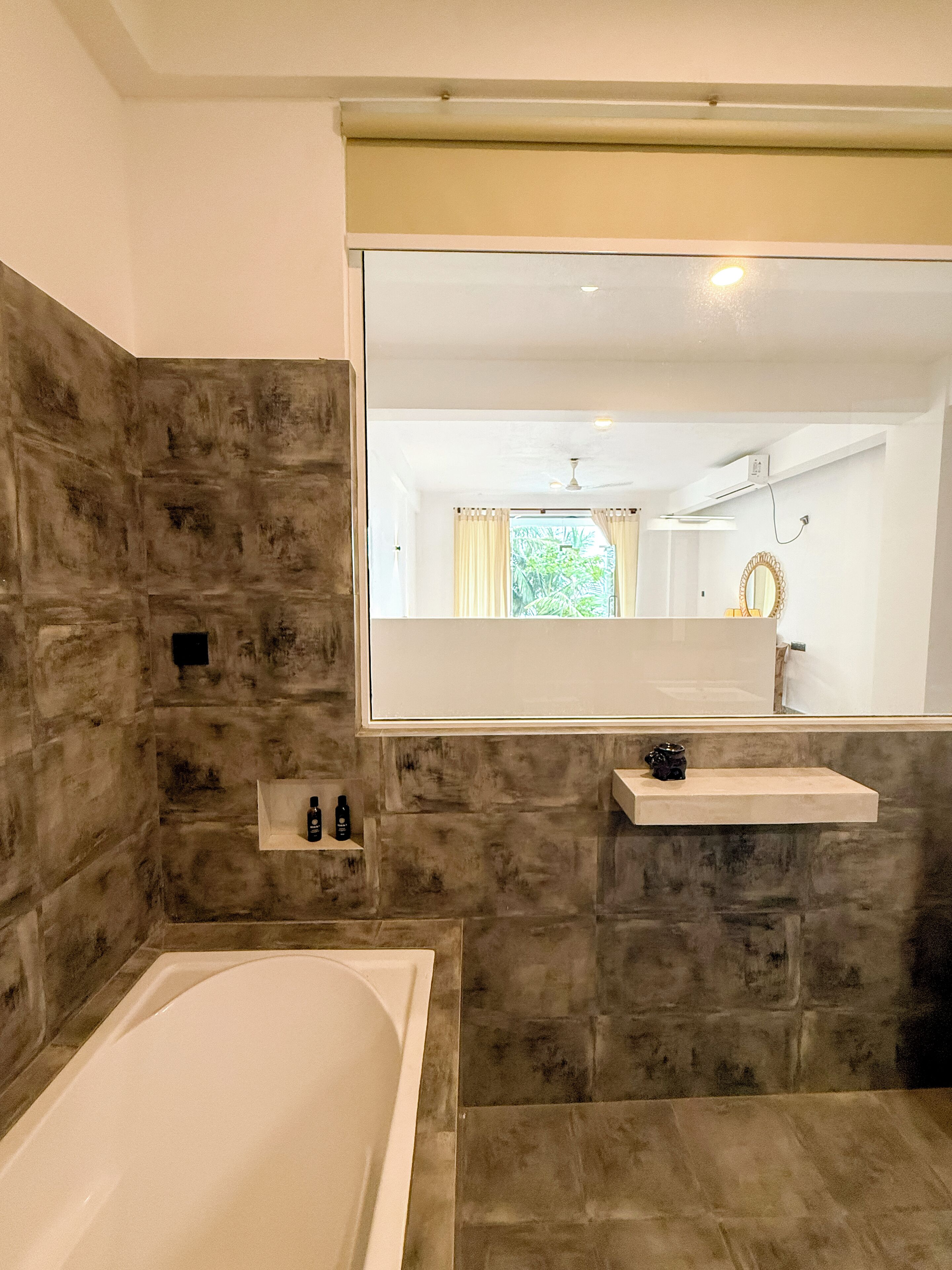 A bathroom with a bathtub, a sink, and a large mirror.