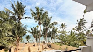 A balcony with a view of a pool and palm trees. - OLA Tangalle (Tangalle)