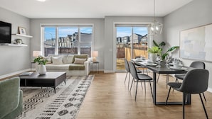Una sala de estar moderna con sofá, mesa de centro y comedor con sillas y una mesa.