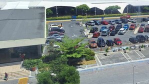 Ein Parkplatz mit mehreren Autos und einem Gebäude, dessen Schild "SOUTHAMALL" zeigt.