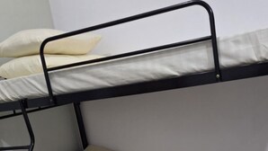 Ein Etagenbett mit zwei Schlafstellen, jeweils ausgestattet mit einer Matratze und Kissen.