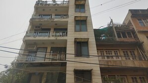A multi-story building with balconies, windows, and visible power lines.