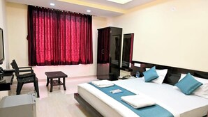 Une chambre d’hôtel avec un grand lit, un bureau, une chaise et une petite table.