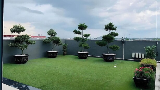 A rooftop garden with artificial grass and potted trees. - Hotel City 88 Sdn Bhd [Batu Pahat] (Batu Pahat)