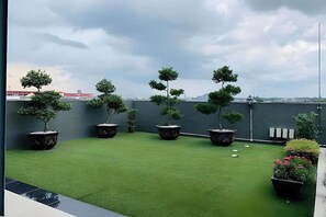 A rooftop garden with artificial grass and potted trees. - Hotel City 88 Sdn Bhd [Batu Pahat] (Batu Pahat)