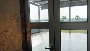 A room with a large window, a door, and a view of an outdoor area with a tiled floor. - Hotel City 88 Sdn Bhd [Batu Pahat] (Batu Pahat)