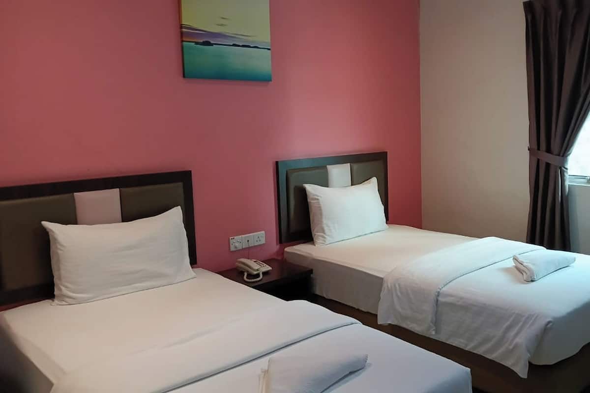 A hotel room with two beds, pink walls, and a painting above the beds.