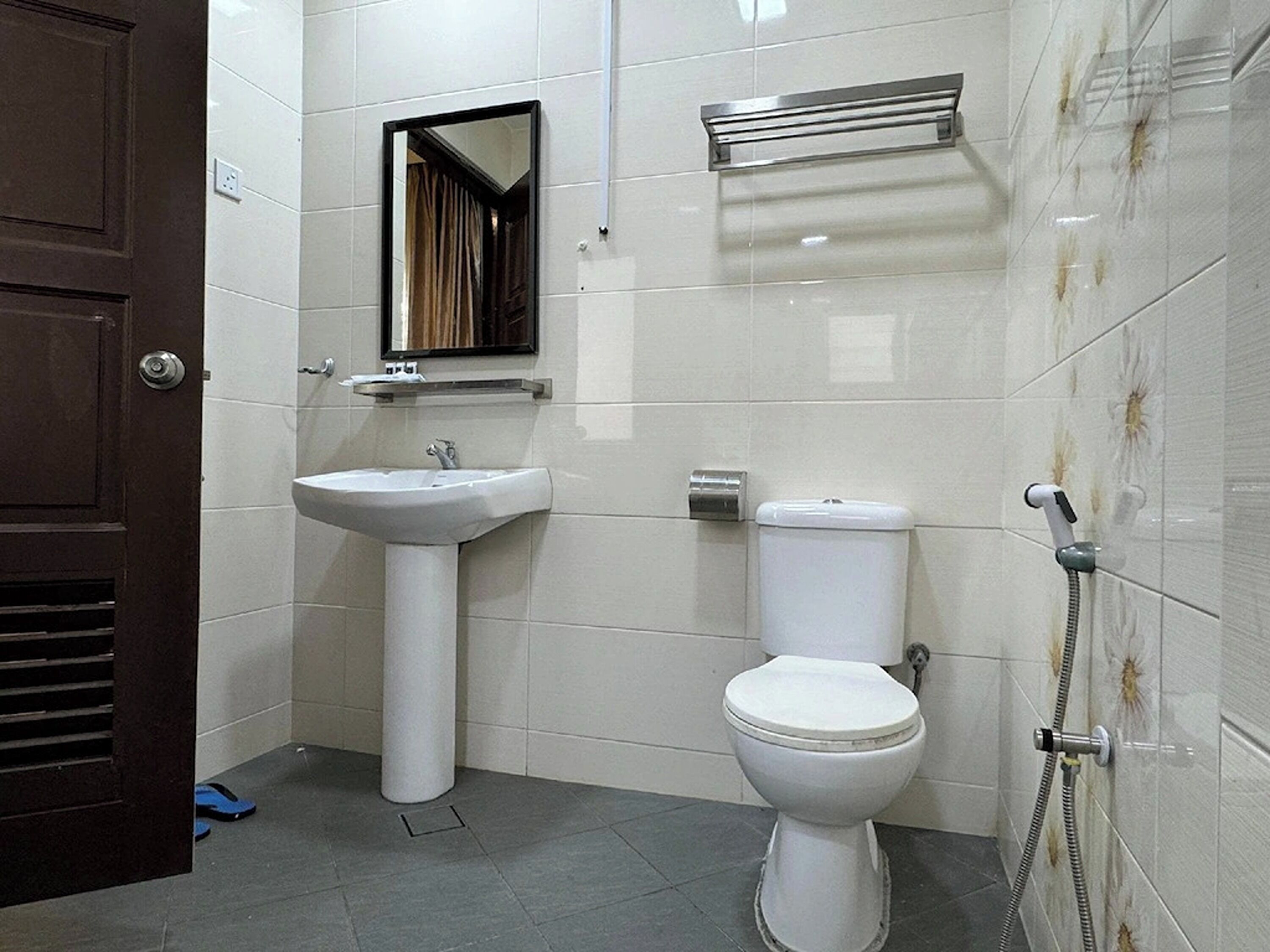 Ein Badezimmer mit weißem Waschbecken, WC und Dusche.