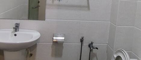 Un baño con lavamanos, inodoro y ducha.