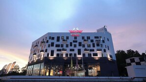A modern hotel with a prominent 'MOTORSPORT HOTEL' sign, multiple floors, and a flat roof. - Arafah Hotel Nilai (Nilai)