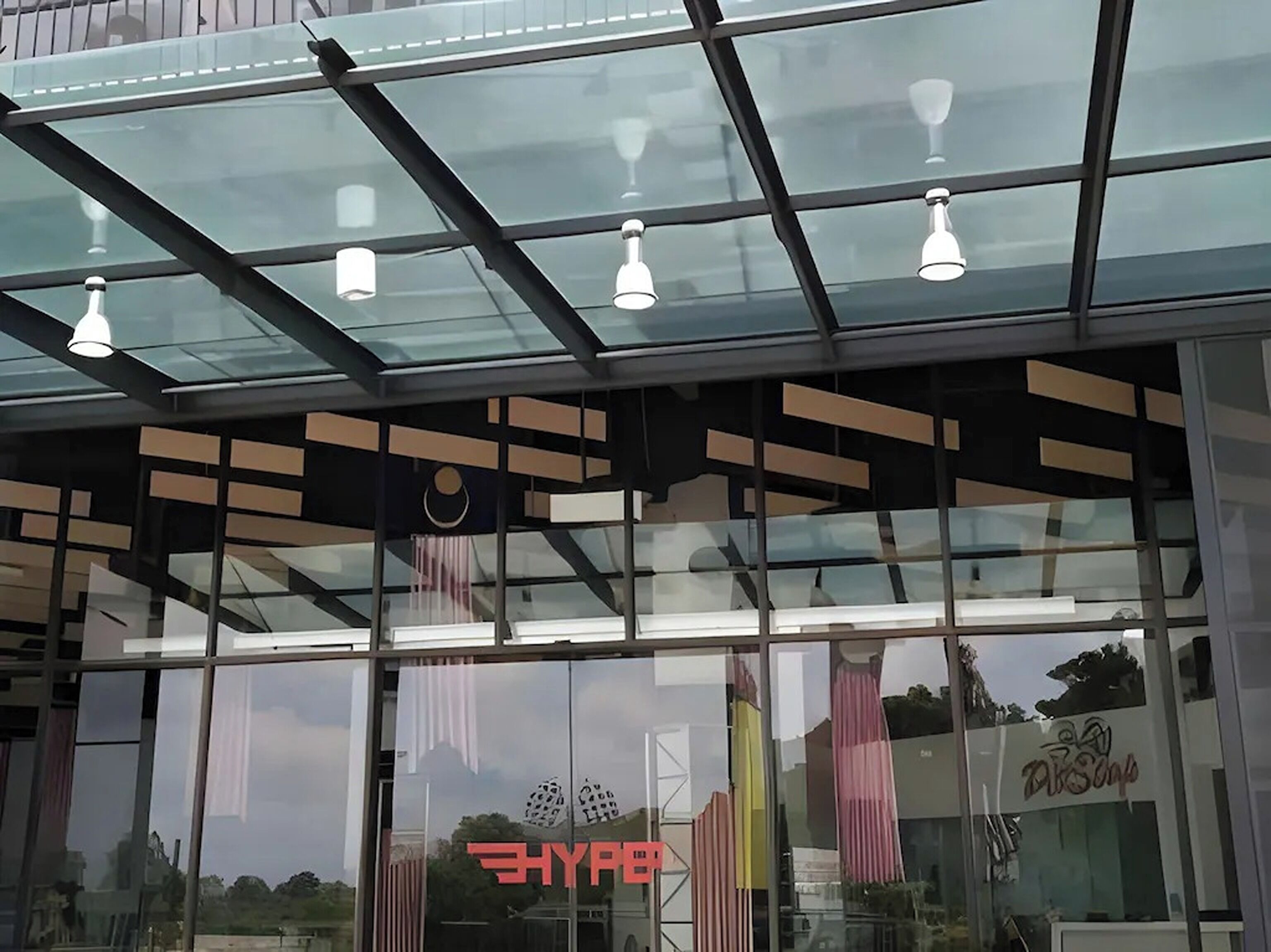 Un bâtiment moderne avec une façade en verre, un logo bien visible et une enseigne sur laquelle on peut lire « HYPE ».
