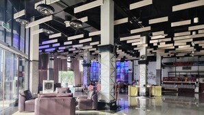 A modern lobby with a bar area, leather seating, and a large window providing natural light. - Arafah Hotel Nilai (Nilai)
