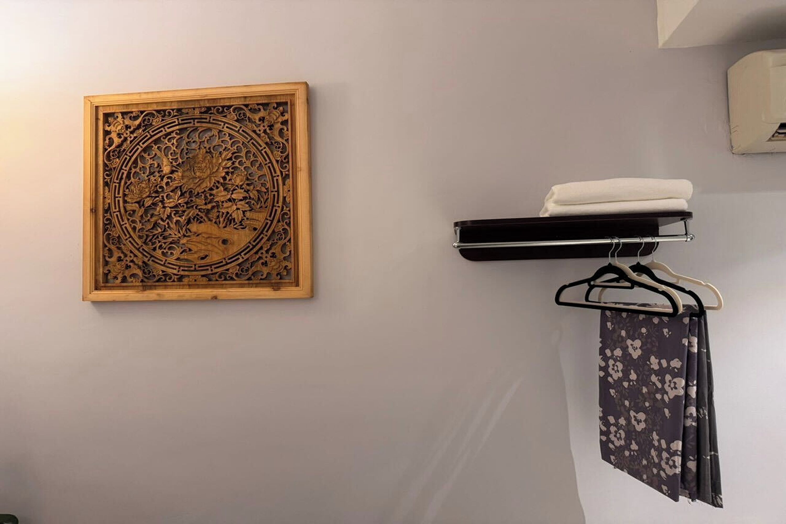Ett badrum med en träpanel som dekorativt inslag, en handduksställning med ett hopvikt handduk och en duschdraperi.